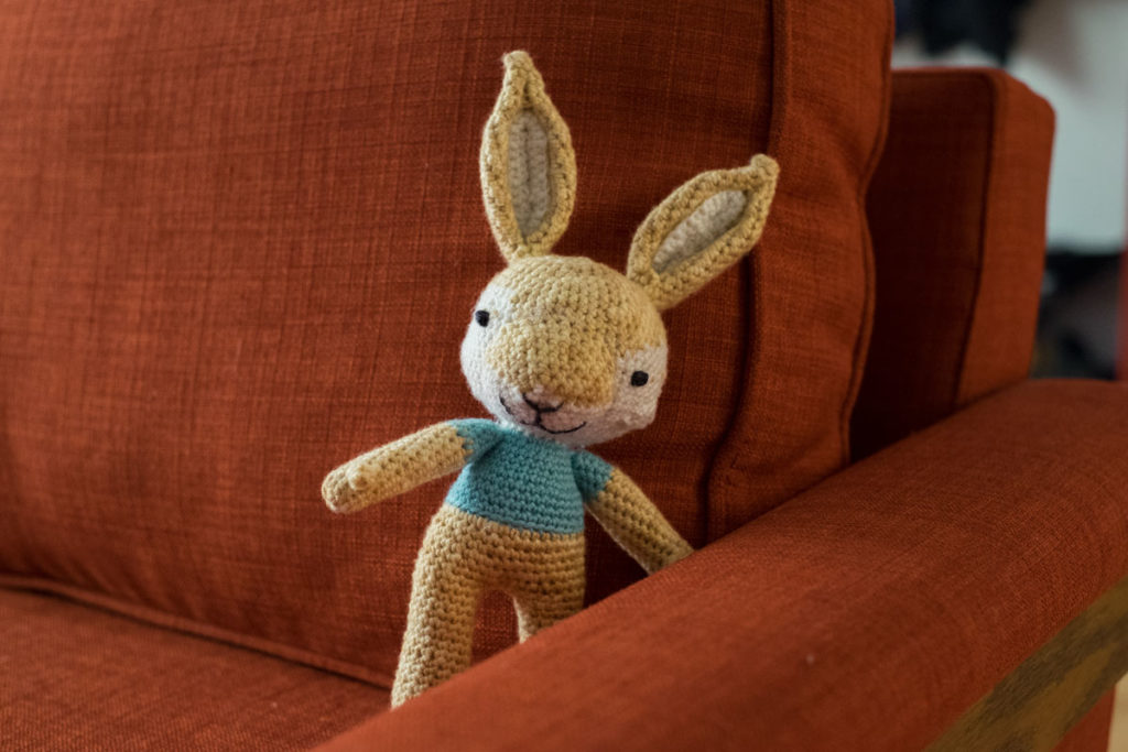 Bunny toy on red couch. 